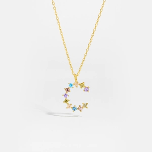 Detail of golden letter C pendant with multi-color cubic zirconia on a fine chain