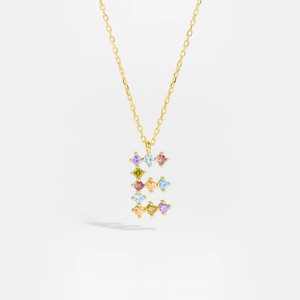 Macro detail of gold necklace with letter E pendant and multi-colored cubic zirconia