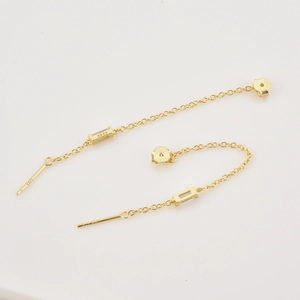 Detalle de pendientes de cadena en plata S925 con cristal de corte esmeralda dorado