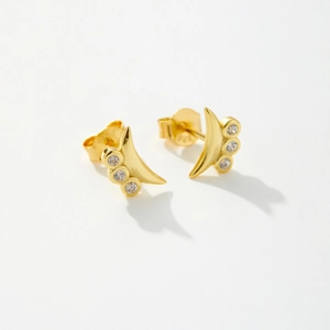 Macro shot of S925 sterling silver crescent studs with three round zircons in gold plating