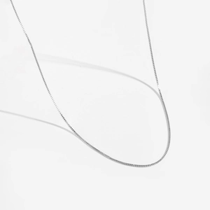 Détail d'une chaîne vénitienne fine en argent sterling S925 avec une texture polie