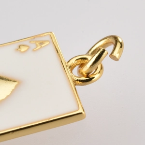 Macro shot of gold Ace of Spades poker charm showing the jump ring connection detail