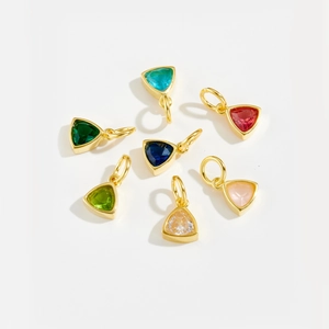 Macro view of triangular faceted colorful zircon pendants in polished gold-plated settings