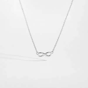 Macro view of a polished S925 sterling silver infinity symbol pendant on a thin chain