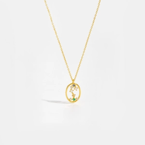 Macro detail of gold constellation pendant with multicolor gems and branch motif