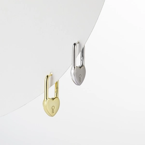 Macro shot of S925 silver heart-shaped lock earrings in gold and silver finish