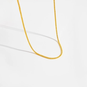 Détails d'un élégant collier tennis doré serti de cristaux scintillants en pavé