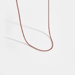 Gros plan détaillé d'un collier tennis en argent sterling serti de zircons rouges brillants