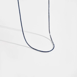 Gros plan du collier tennis en argent avec pierres bleues saphir et sertissage à griffes