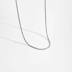 Vue macro détaillée d'un élégant collier tennis en argent 925 avec des pierres violettes