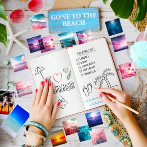 Flat lay of square cartoon ocean scenery stickers scattered around travel props