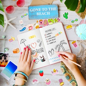 Flat lay of colorful waterproof cartoon stickers on wood background for DIY laptop décor