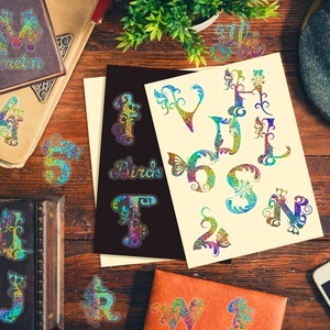 Detailed flat lay of floral laser alphabet stickers on a vintage wooden desk setup