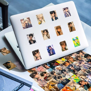 Anime boy stickers decorating a laptop lid with creative artistic illustrations