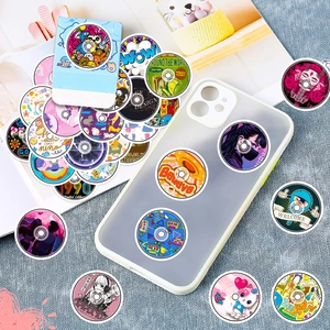 Detail of round retro CD-style vinyl stickers on phone case and magazine background