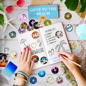 Detailed view of colorful vinyl record stickers on a travel journal with beach props
