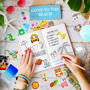 Close-up of cute waterproof animal stickers for kids on a summer beach themed desk