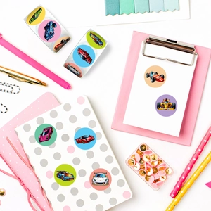 Detailed view of colorful racing car stickers on a pink notebook and office supplies