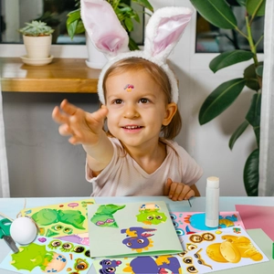 Close-up of a girl playing with colorful dinosaur mix-and-match face DIY stickers for kids