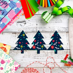 Close-up of DIY tree-shaped Mother's Day gift tags with MOM floral pattern on wood