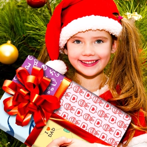 Gros plan d'un coffret cadeau fête des pères avec ruban rouge devant un sapin de Noël décoré