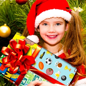 Boîte cadeau avec papier à motifs sportifs et grand nœud rouge pour Noël festif