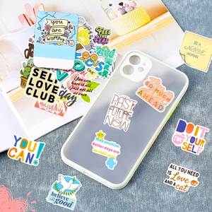 Close-up of colorful motivational PVC stickers on a transparent mobile phone case