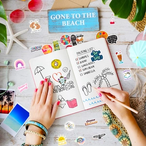 Close-up of inspirational summer stickers with rainbow and heart patterns on a desk