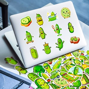 Close-up of cute cartoon pickle stickers applied on a laptop lid with vibrant green colors