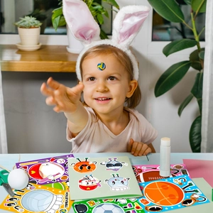 Enfant jouant avec des autocollants de ballons de sport cartoon pour le bricolage DIY