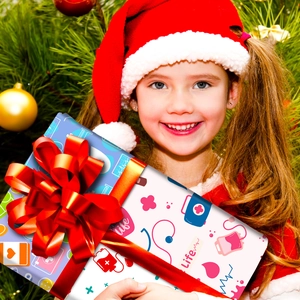 Fillette tenant un cadeau de Noël avec papier à motifs médicaux et ruban rouge