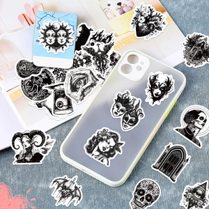 Close-up of black and white gothic punk stickers with eyes and skulls on a phone case
