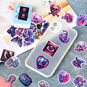 Macro shot of purple gothic stickers on a phone case featuring skull and eye motifs