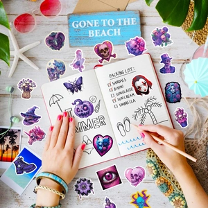 Purple gothic stickers featuring skulls and occult patterns displayed for journaling use