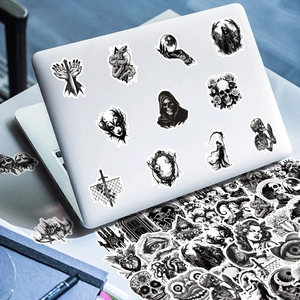 Gothic punk stickers with skull and demon motifs displayed on a silver laptop surface