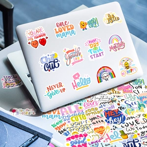 Macro view of motivational English quote stickers on a laptop with rainbow and sun designs