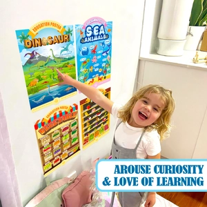 Toddler pointing at educational wall posters featuring cartoon dinosaurs and sea animals