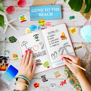 Flat lay of colorful summer aesthetic stickers with motivational quotes on wood