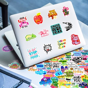 Nahaufnahme bunter Motivationsaufkleber mit positiven Sprüchen auf einem weißen Laptop