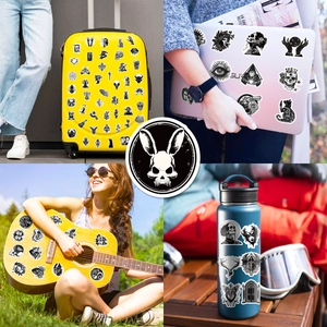 Detailed view of gothic punk stickers on luggage, laptop, guitar, and water bottle