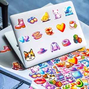 Détail macro de stickers étanches style pixel art rétro sur un ordinateur portable