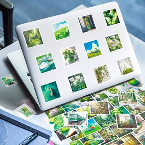 Dettaglio di adesivi naturali verdi su laptop con illustrazioni di foreste e prati