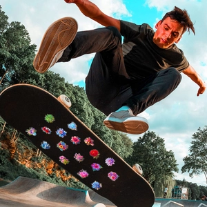 Colorful floral laser PET stickers applied on a black skateboard in an outdoor park