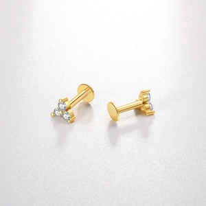 Gros plan de boucles d'oreilles en argent 925 doré avec trois zircons en forme de triangle