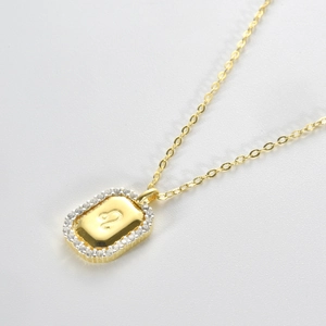 Detailed macro view of gold-plated Leo zodiac pendant with cubic zirconia edge inlay