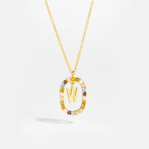 Macro detail of gold necklace featuring letter W pendant with colorful cubic zirconia