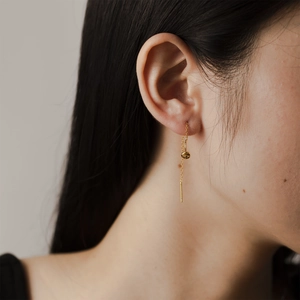 Detail shot of elegant long S925 silver chain earrings with gold plated circular disc