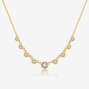 Detail of gold necklace featuring nine graduated bezel-set clear round gemstones