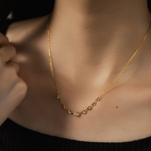 Elegant S925 sterling silver gold-plated necklace with circular zirconia stones on collarbone