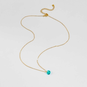 Détail du collier en argent S925 plaqué or avec un pendentif en cristal turquoise